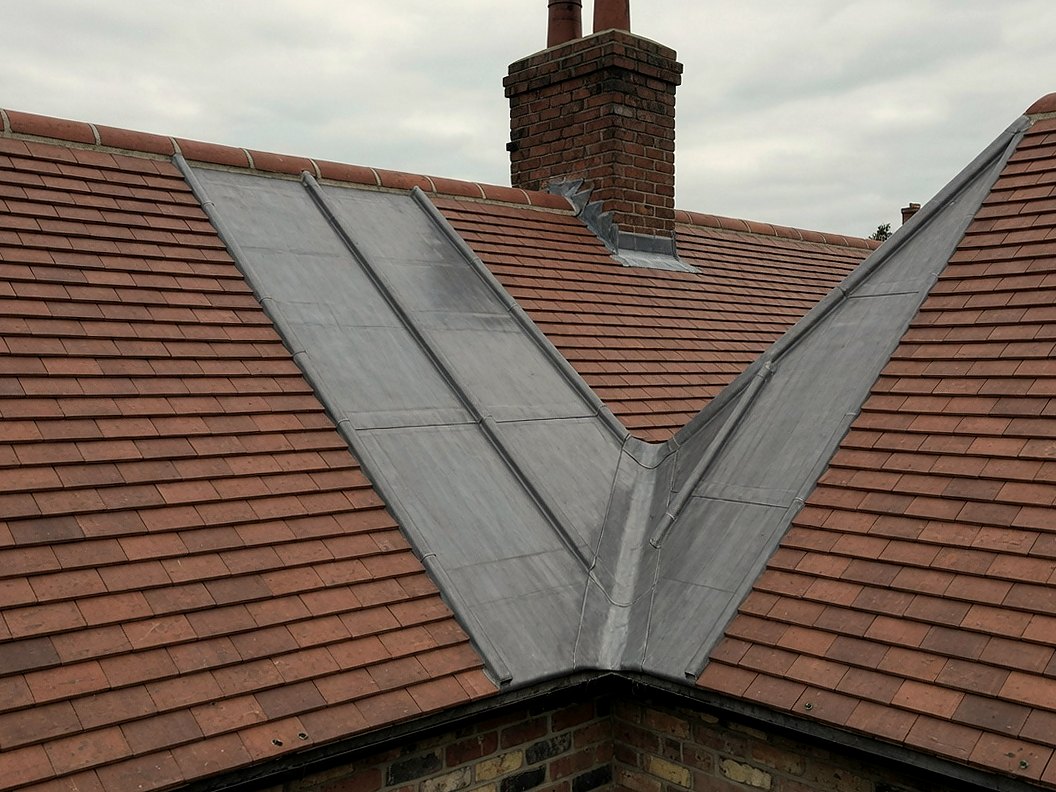 Lead valley flashing between two clay-tiled roof pitches